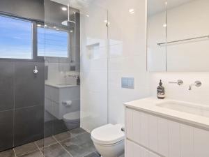une salle de bain blanche avec toilettes et lavabo dans l'établissement Villa Nova Gerroa, à Gerroa