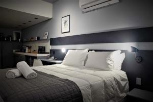 una camera da letto con un grande letto con cuscini bianchi di Studio 107/Floripa - Estilo no coração da cidade a Florianópolis