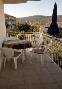 a patio with a table and chairs and an umbrella at Apartments Slaven-50m from beach in Vinišće