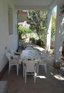 a white table and chairs on a patio at Apartments Slaven-50m from beach in Vinišće