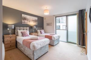 a bedroom with two beds and a large window at AJY Birmingham City Centre Viva Apartment in Birmingham