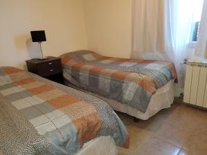 une chambre avec deux lits et une lampe sur une table de chevet dans l'établissement DEPARTAMENTO CALAFATE CENTRICO #2, à El Calafate