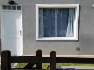 une maison avec une fenêtre et un banc à côté dans l'établissement DEPARTAMENTO CALAFATE CENTRICO #2, à El Calafate