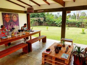 a person sitting at a table with a laptop at Pousada Casa de João Kitehouse in São Miguel do Gostoso