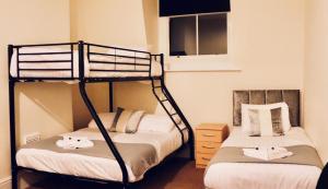a bedroom with two bunk beds and a window at The New Alexandra Hotel in Llandudno