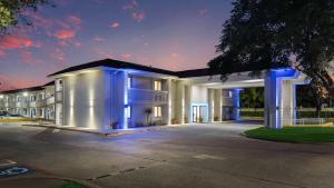 a large white building with blue lights on it at Motel 6-Addison, TX - Dallas in Addison