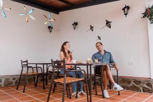 Hotel Galapagos Suites B&B في بويرتو أيورا: يجلس رجل وامرأة على طاولة في مطعم