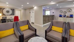 a living room with two chairs with yellow pillows at Best Western Clermont in Cincinnati