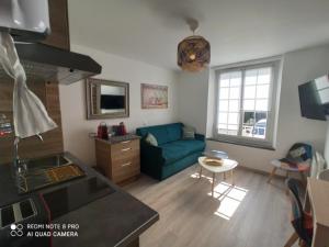 sala de estar con sofá azul y cocina en Cosy Solidor T2 avec jardin terrasse 100m plage, en Saint-Malo