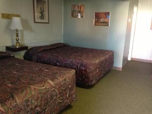 a hotel room with two beds and a window at Jamestown Motel in Jamestown