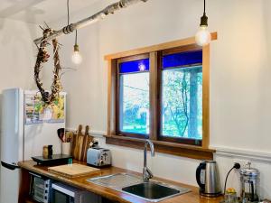een keuken met een wastafel en een raam bij Quail Farm, Colonial charm in Nelson