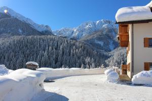 a building covered in snow with mountains in the background at ALMRESIDENZ UNTERRAIN -1 km BY CAR DISTANCE SKI SLOPES KRONPLATZ in Valdaora +179 photos