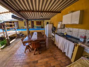 a kitchen with a wooden table and chairs and a kitchen with a counter at Casa Ayurveda in Alto Paraíso de Goiás
