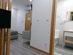 Uma televiso e/ou sistema de entretenimento em ALOJAMENTO GIRASSOL - Guest House - Quarto com casa de banho privativa