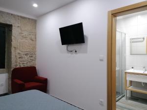 Uma televiso e/ou sistema de entretenimento em ALOJAMENTO GIRASSOL - Guest House - Quarto com casa de banho privativa