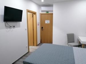 Uma televiso e/ou sistema de entretenimento em ALOJAMENTO GIRASSOL - Guest House - Quarto com casa de banho privativa