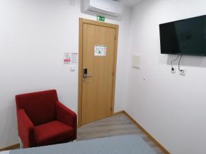 Uma televiso e/ou sistema de entretenimento em ALOJAMENTO GIRASSOL - Guest House - Quarto com casa de banho privativa