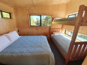 a bedroom with two bunk beds and a ladder at Treescapes in Punakaiki