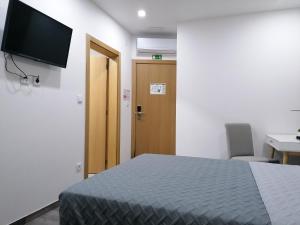 Uma televiso e/ou sistema de entretenimento em ALOJAMENTO GIRASSOL - Guest House - Quarto com casa de banho privativa
