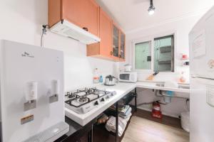 uma cozinha com electrodomésticos brancos e armários de madeira em Itaewon Yellow Guesthouse em Seul