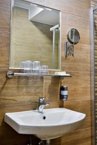 a bathroom with a white sink and a mirror at Thermál Panzió in Mórahalom