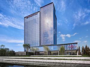 a rendering of a tall building with a river in front at Crowne Plaza Qidong, an IHG Hotel in Qidong