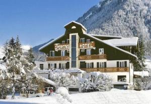 a large building in the snow with a mountain at Hôtel Le Sporting in Morzine
