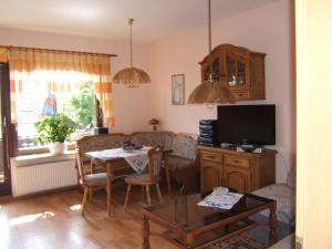 ein Wohnzimmer mit einem Tisch und einem TV in der Unterkunft Ferienwohnung Veit in Pennewitz