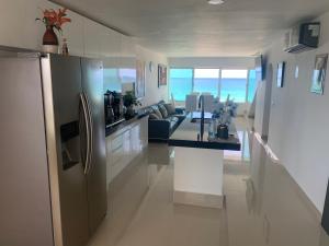 cocina y sala de estar con nevera de acero inoxidable en Penthouse frente al mar en Cancún