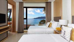 a hotel room with two beds and a view of the ocean at Amari Phuket in Patong Beach