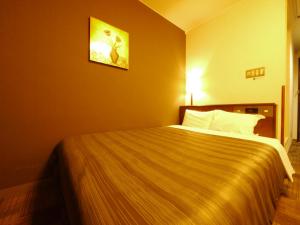 a hotel room with a large bed in a room at Hotel Route-Inn Ageo in Ageo