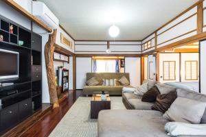 ein Wohnzimmer mit einem Sofa und einem TV in der Unterkunft Samurai House - Large Family House, West Shinjuku in Tokio