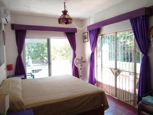 1 dormitorio con cama y ventana grande en Casa Magua, en Bucerías