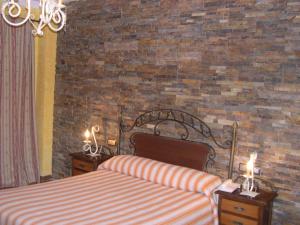 una camera con due letti e un muro di mattoni di Hotel El Doncel ad Atarfe