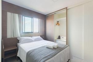 a bedroom with a white bed with a window at Luxuoso Flat de 2 qts ao lado do CASV e do Riomar in Recife +36 photos