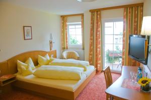 1 Schlafzimmer mit 2 Betten, einem Schreibtisch und einem TV in der Unterkunft Gasthof Rose in Flachslanden