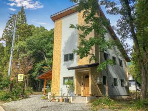 a home with a brick and white building at Villa 777 Hakuba in Hakuba