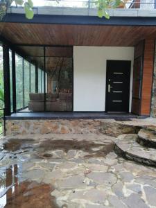 un edificio con una puerta negra y un patio de piedra en Mazamitla Pinos del Rio, en Mazamitla