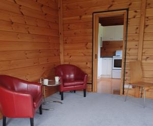 a room with a table and chairs and a kitchen at Aqua On The Beach in Auckland