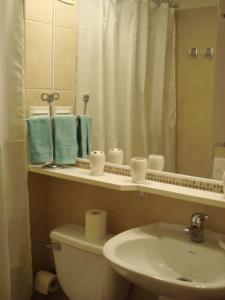 a bathroom with a toilet and a sink and a mirror at Departamento Reñaca Torremolinos XII in Viña del Mar