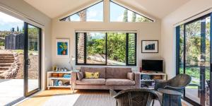 a living room with a couch and large windows at Art Lovers Retreat in Onetangi