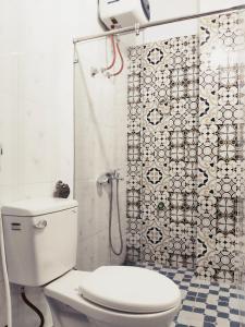 e bagno con doccia e servizi igienici bianchi. di Nhà nghỉ Phúc Anh - Bắc Kạn a Bak Kan