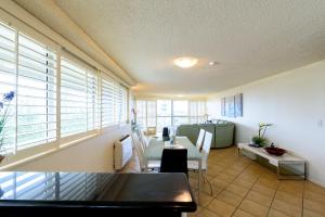 a living room with a table and chairs and windows at Main Beach Waterfront Apartment in Gold Coast