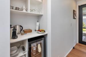 cocina con armarios blancos y chimenea en Roy and Anns Haven, en One Tree Point