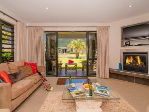 a living room with a couch and a fireplace at Villa 51 - Pauanui Holiday Home in Pauanui