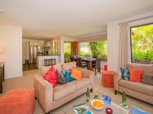 a living room with a couch and a table at Villa 51 - Pauanui Holiday Home in Pauanui