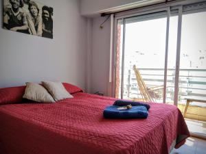 a bedroom with a red bed with a cat laying on it at Luminoso monoambiente en Recoleta in Buenos Aires +19 photos