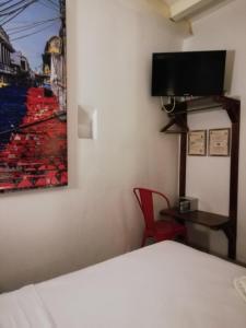 a bedroom with a bed and a painting on the wall at Casa Ebano 967 in Cartagena de Indias
