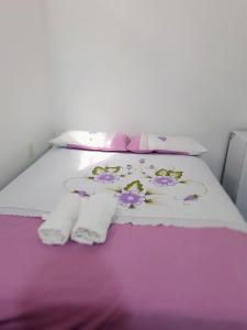 1 cama con manta y toallas de color púrpura y blanco en Residência dos Félix, en Morro de São Paulo
