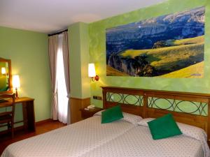 1 dormitorio con 1 cama con una pintura en la pared en Hotel Arnal, en Escalona